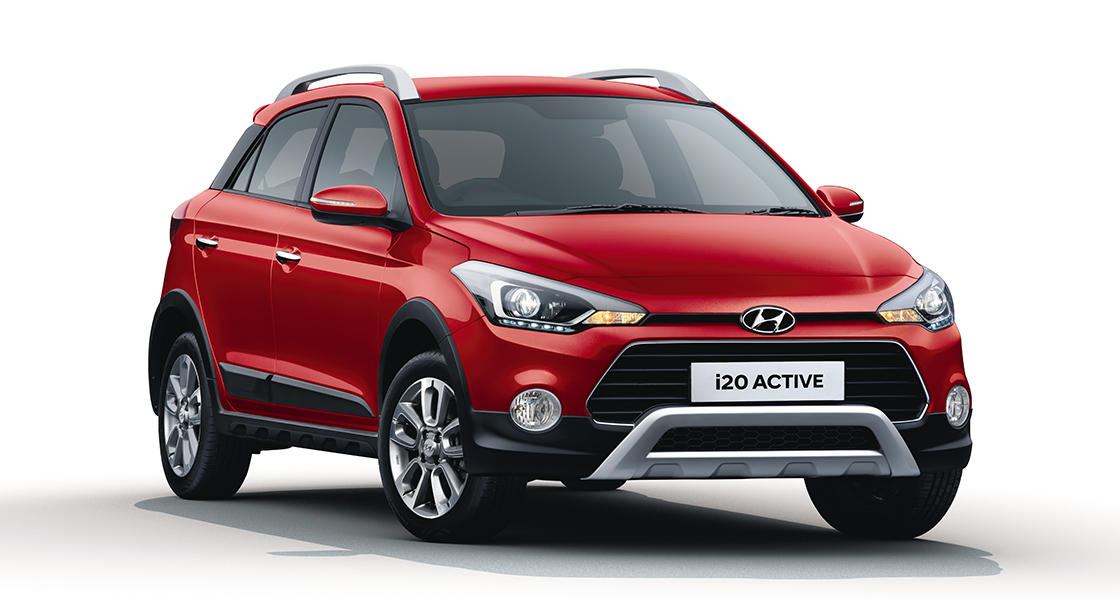 Left side view of red i20 active parked in front of the building
