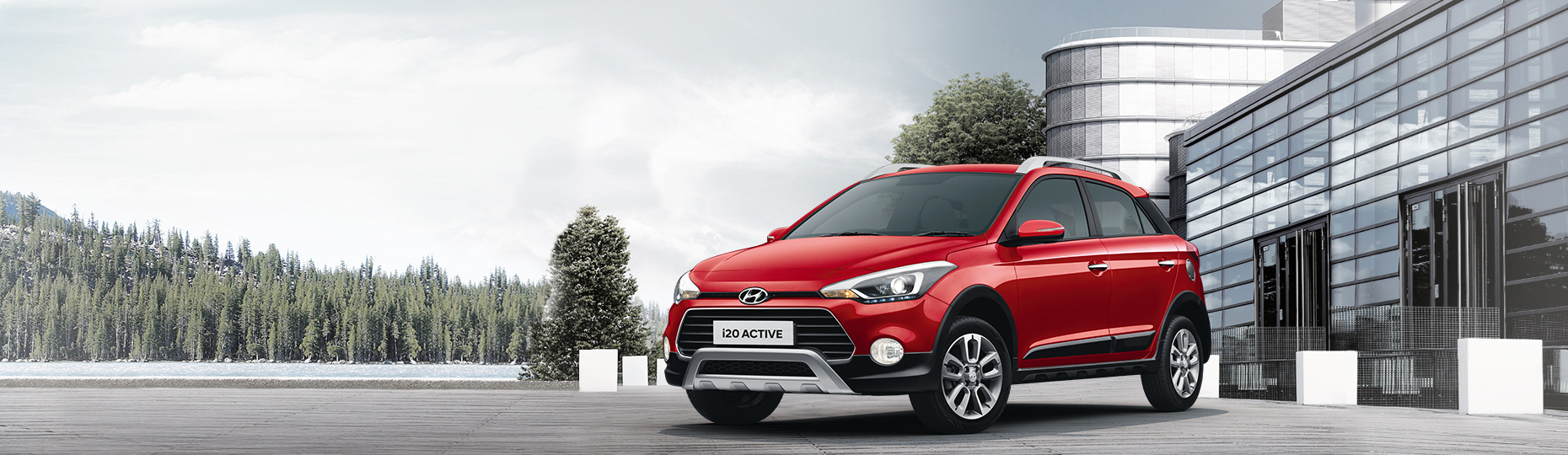 Red i20-Active is placed in front of a building with white color